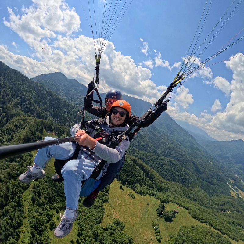 Tandem paragliding pilot and passenger above Brasov